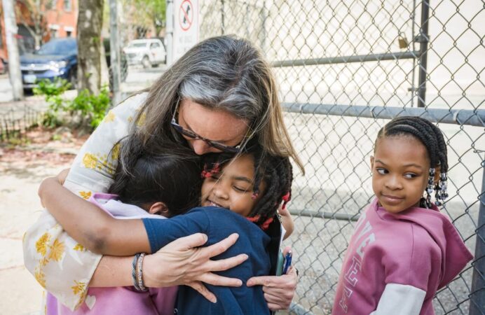 Teacher hugging students